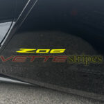 Black Z06 Corvette with accelerate yellow Z06 emblem overlay