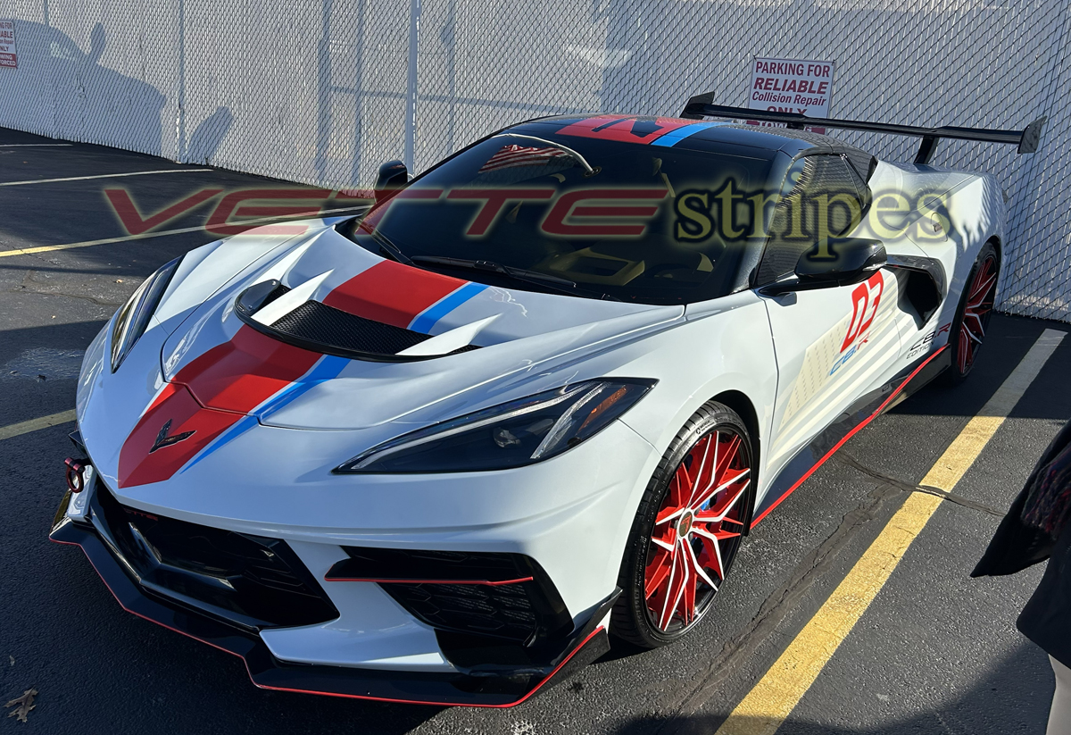 White C8 Corvette with red and blue fulll length racing stripes White C8 corvette Stingray vert with cardinal red and rapid blue racing stripes
